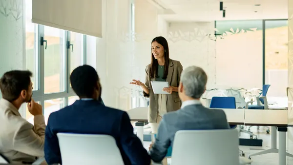 Young businesswoman leading a meeting while holding a tablet