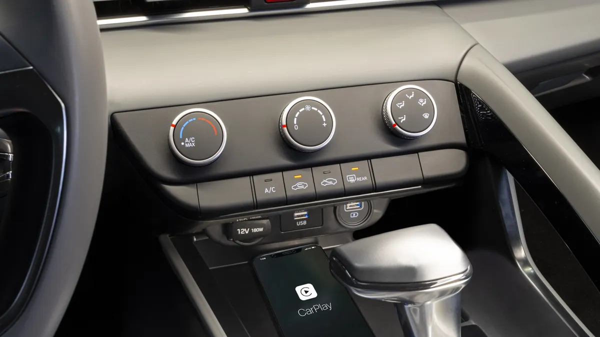 Three black knobs of a climate control system inside a car.