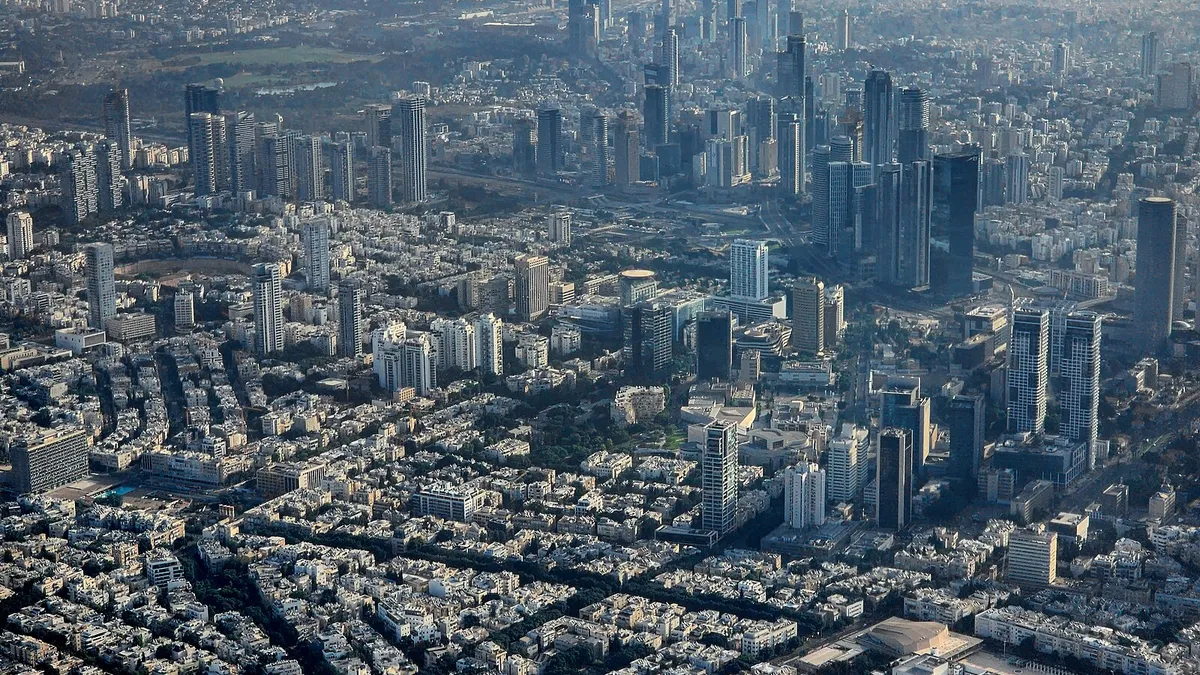 A skyline shot of Tel Aviv in Israel, a densely packed urban landscape with a visible coast.