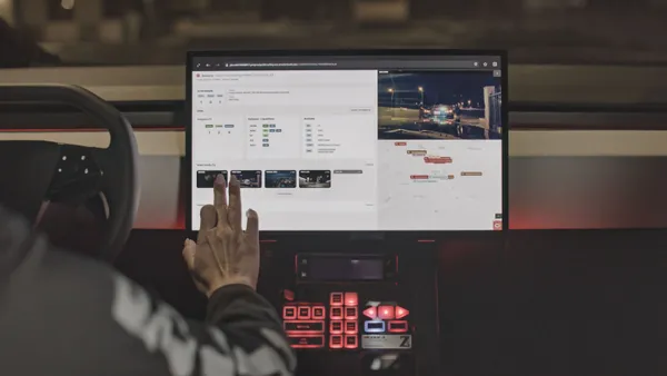 Cybertruck running software on screen and driver is interacting with it.