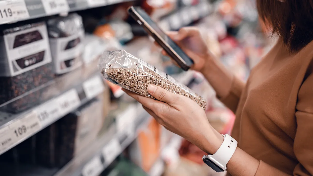 Woman shopping in supermarket and reading product information. Costumer buying food at the market.