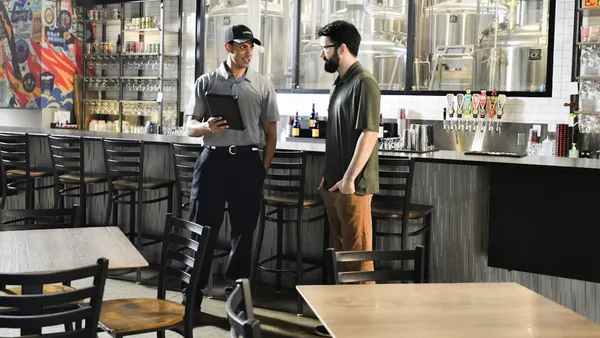 Two people talking at a restaurant high top