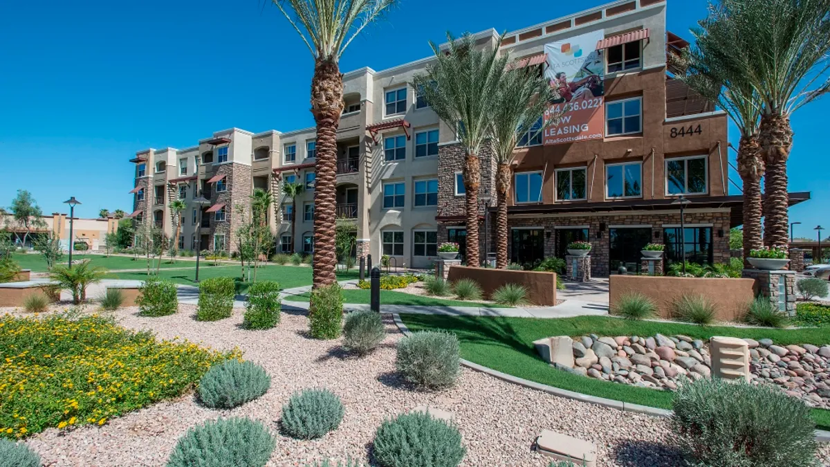 Four-story apartment building with Palm tress in the foreground.