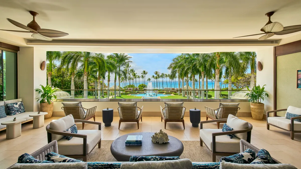 An open-air spa has a view of palm trees.