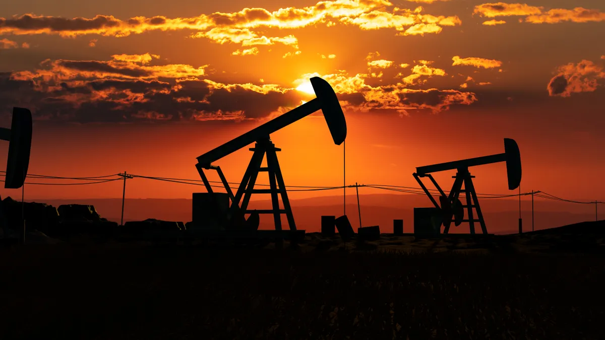 Silhouette of oil pumps with the sun setting behind.