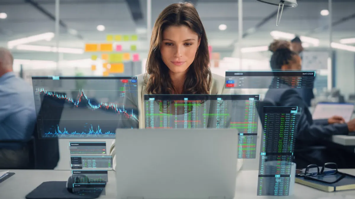 Woman using laptop in the office with VFX Hologram Visualizing Stock Exchange