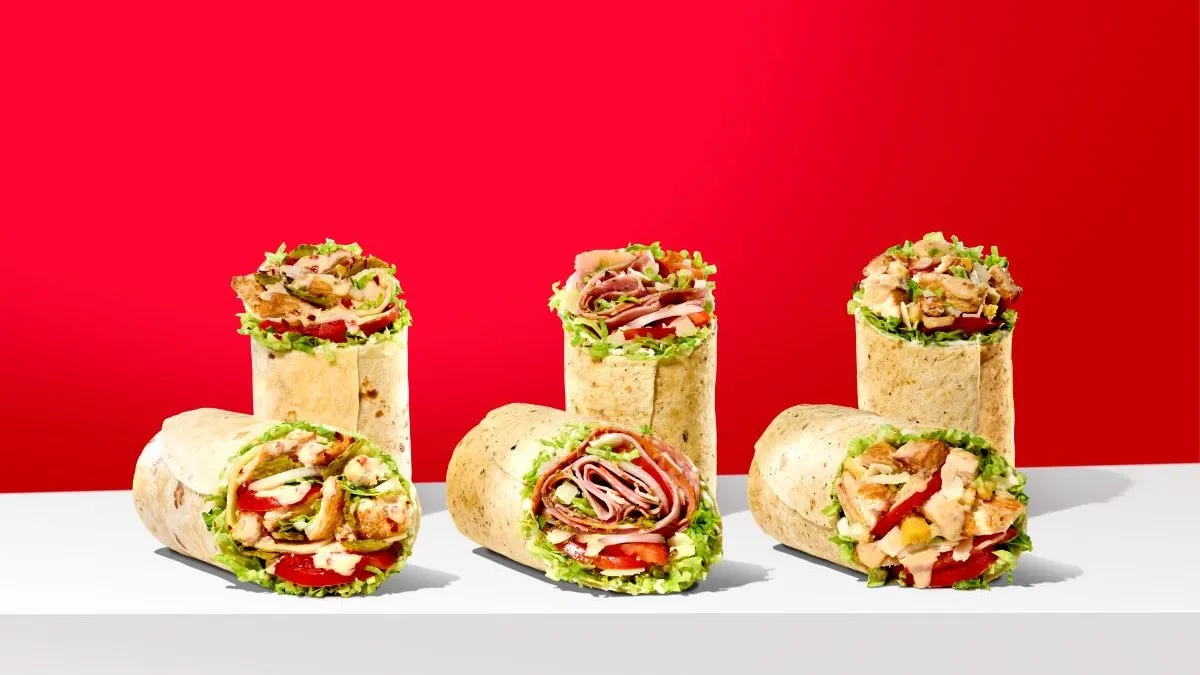 Three wraps from Jimmy John's in front of a red background