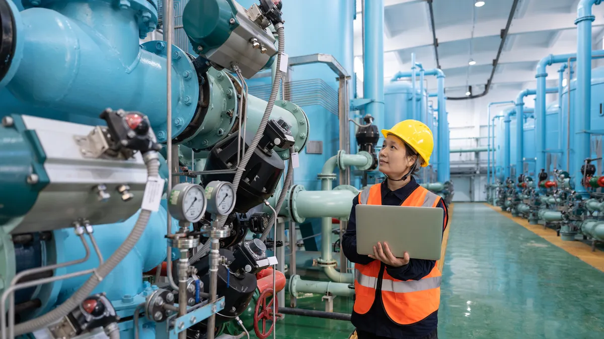 A worker evaluates equipment in a manufacturing facility.