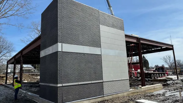 A photo of a partially built modular construction building. The frame is up and some but not all of the walls have been put in place.