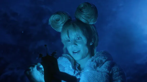 A Dr. Seuss-inspired character is bathed in the blue light of a mobile device in a holiday ad from Walmart