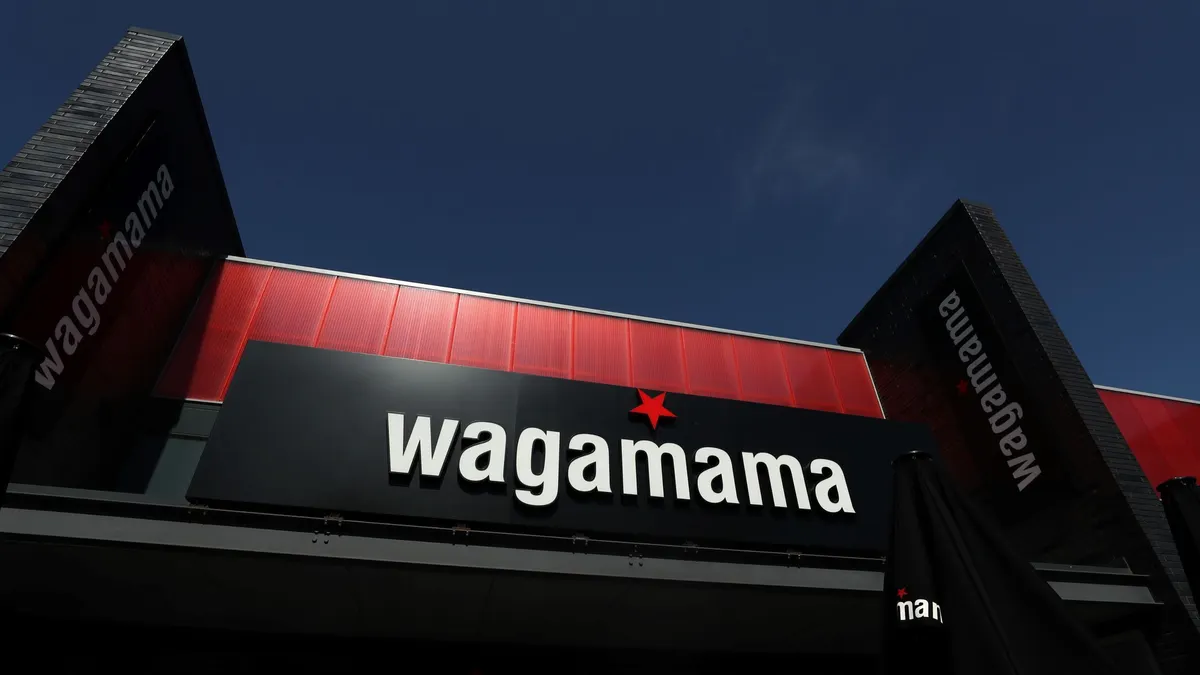 An iamge of a building with black facade and white logo that says "Wagamama."