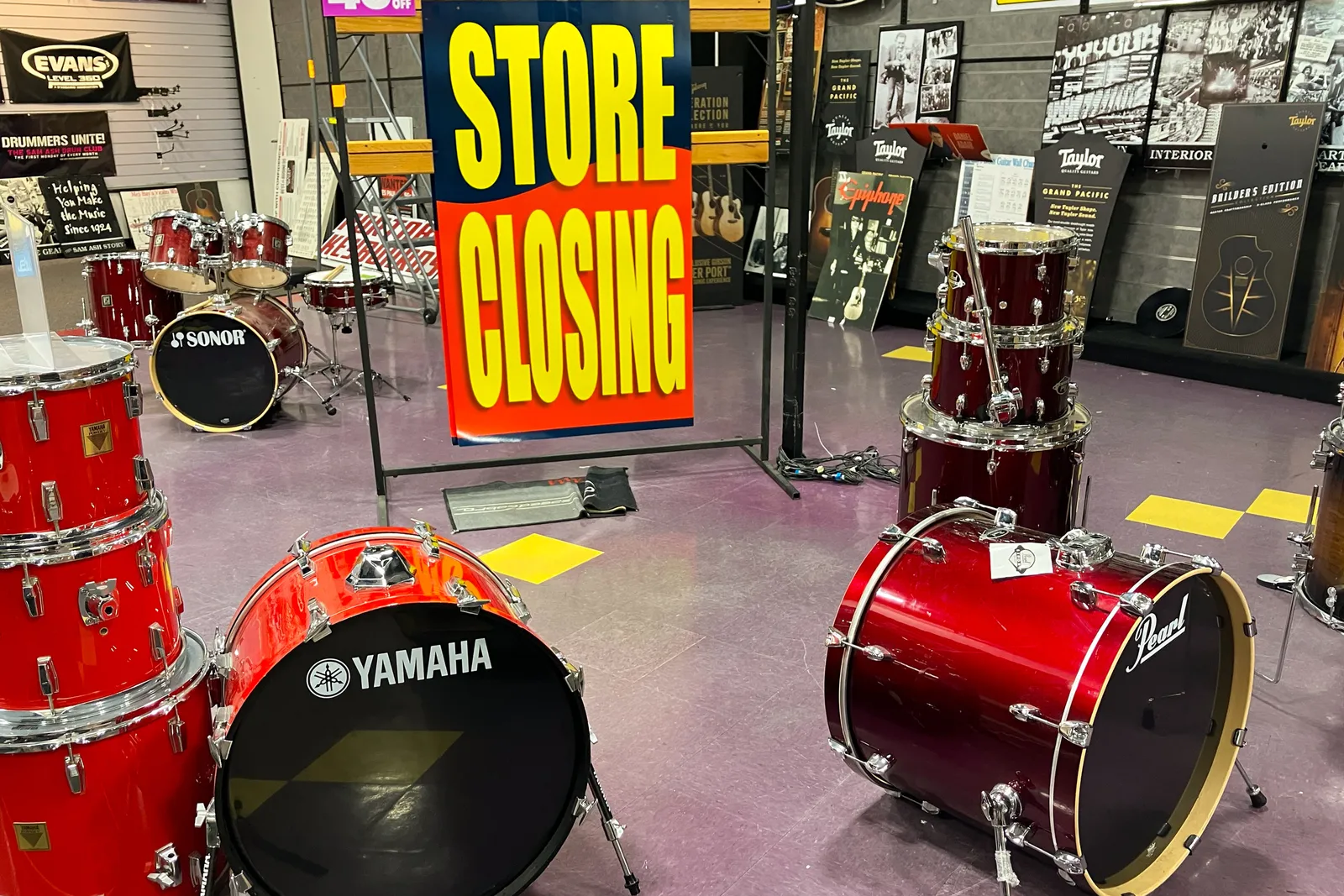 A selection of drum kits on display around a large store closing sign