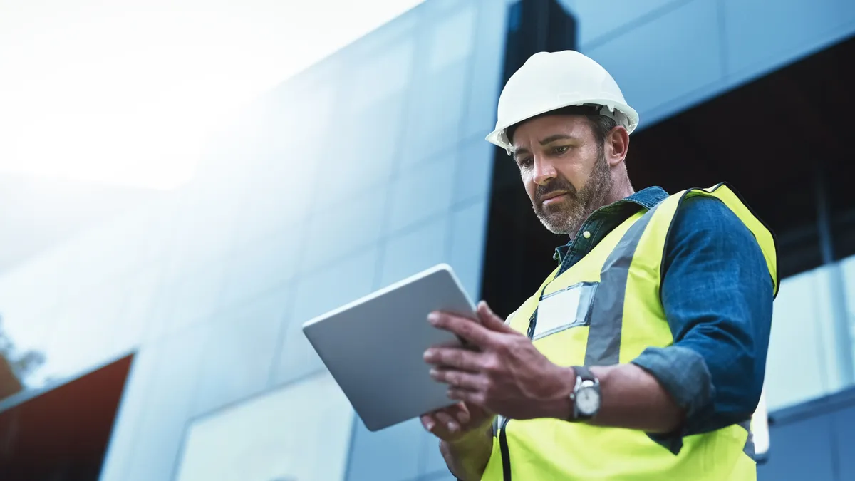 A shot of a building worker using a digital tablet at a construction site.