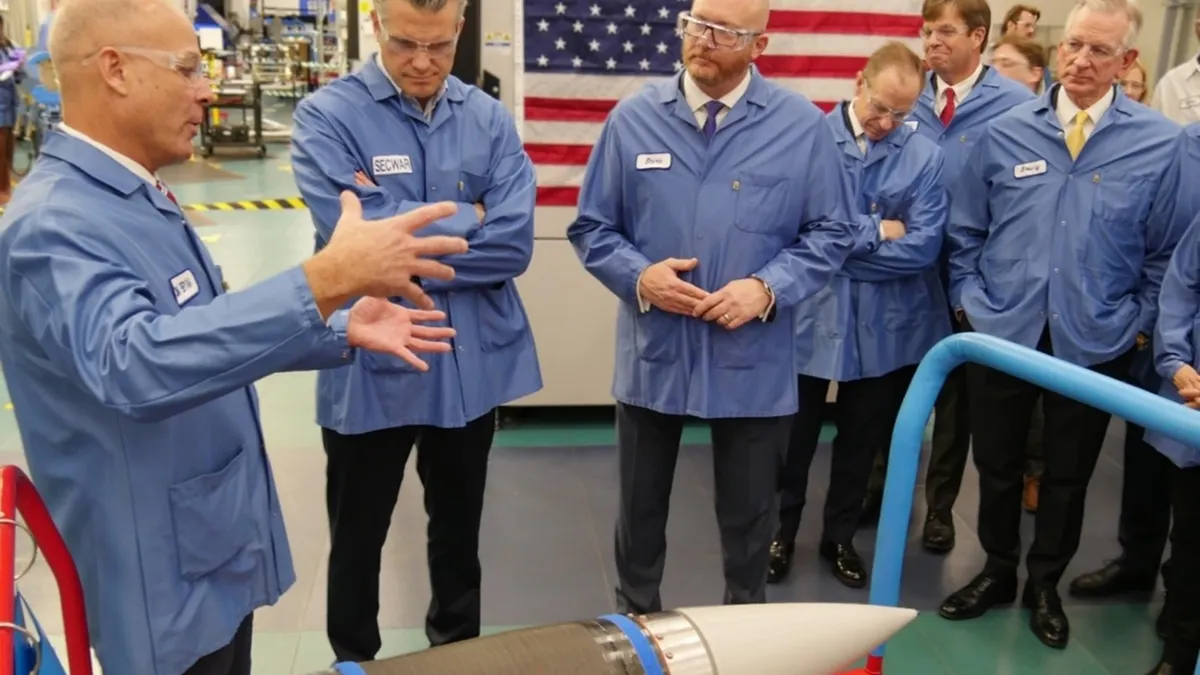 Six people wearing blue protected coats and goggles