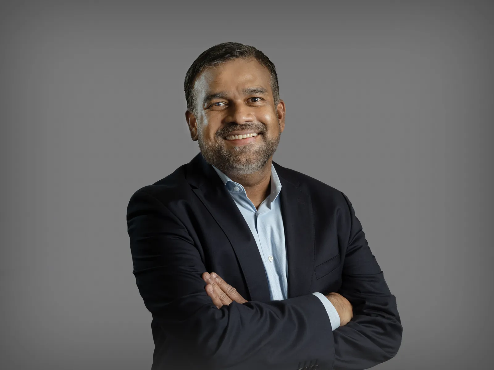 Man standing in suit with arms folded