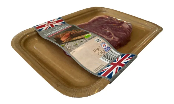 Steak on a vacuum-packed fiber tray with a plastic cover.