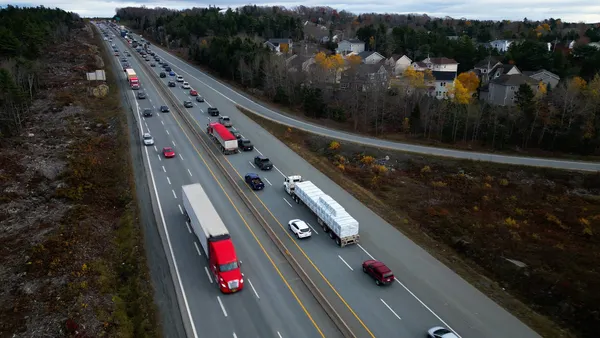 Passenger cars and heavy-duty trucks traverse a highway.
