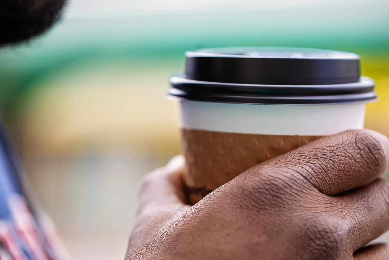 A hand holding a coffee cup