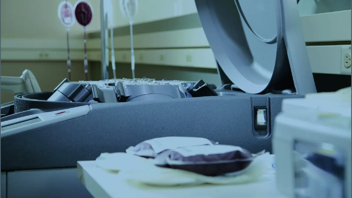 Close up of bags of blood in front of a device with a rounded lid.