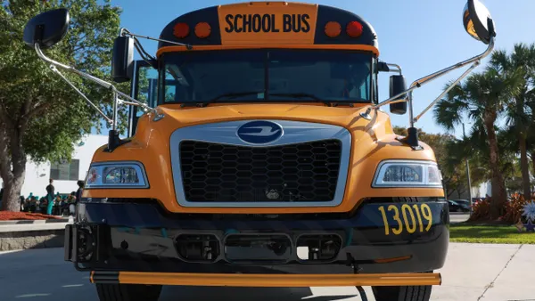 A yellow electric school bus seen from the front