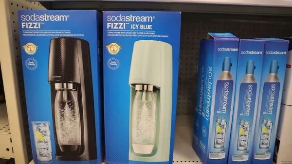 SodaStream systems in boxes sit on a retail shelf, next to boxes of SodaStream CO2 cartridge refills.