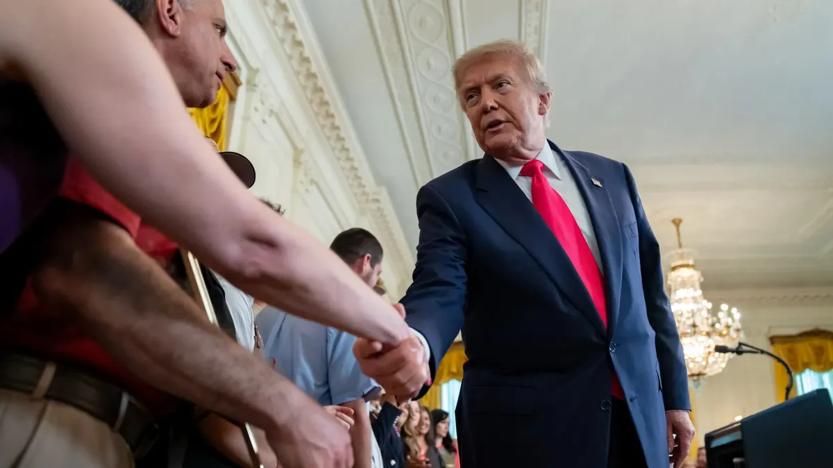 President Donald Trump shakes hands with an attendee of an event at the White House promoting a sweeping tax policy measure.