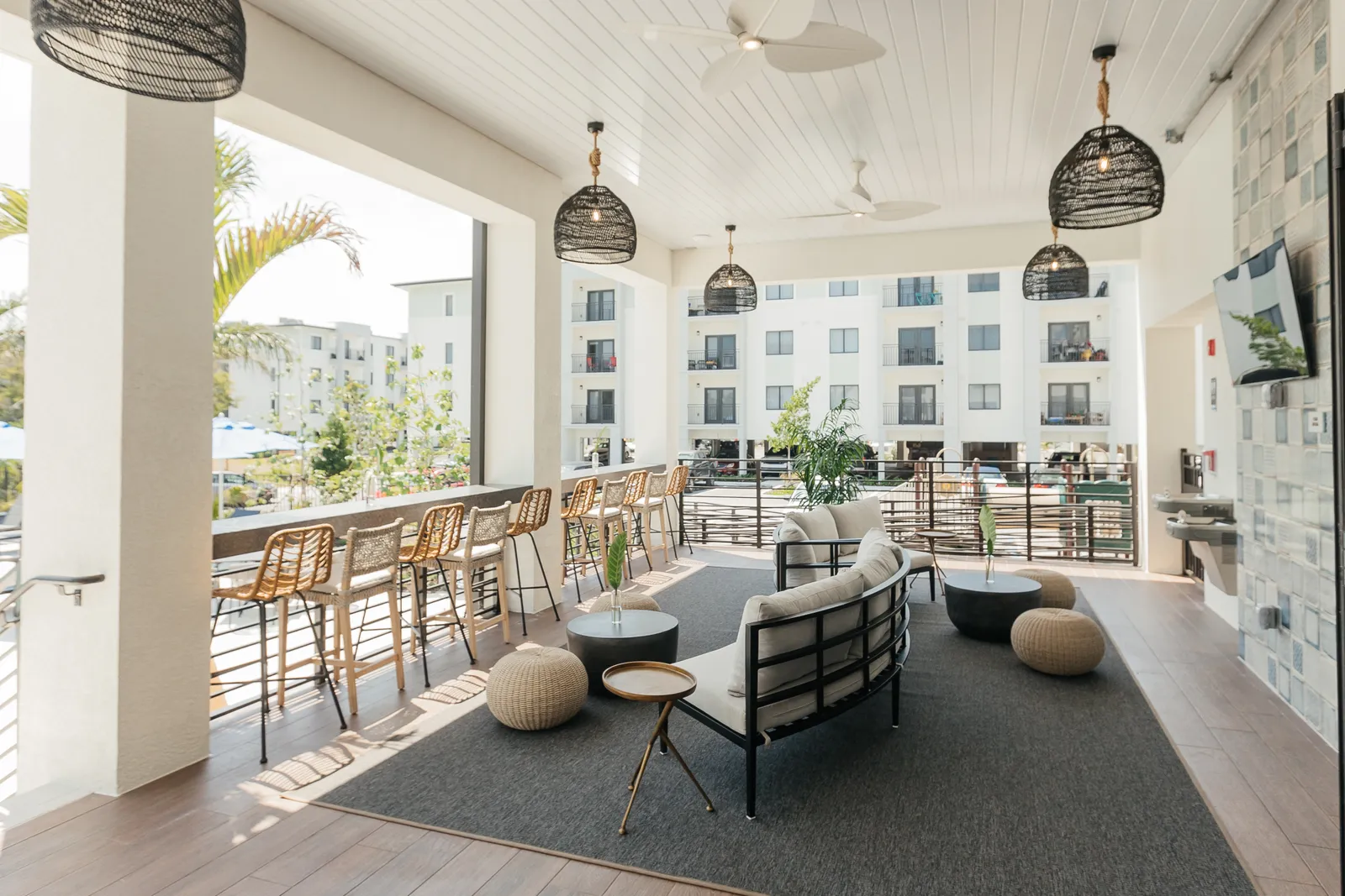 A patio with a countertop, chairs, and a couch.