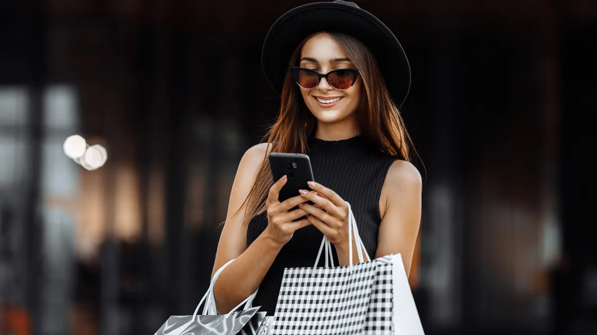 Girl in a black dress and hat, using a mobile phone