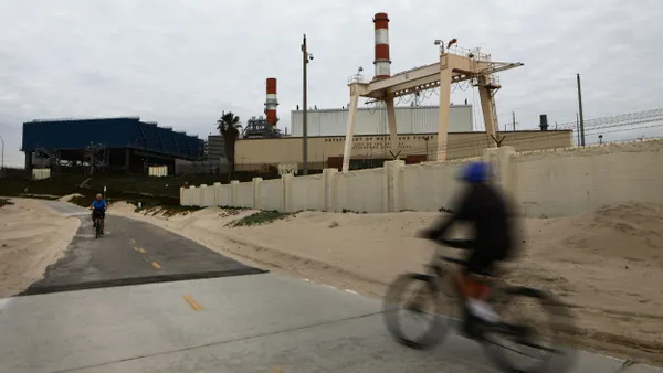 A person bikes past a power plant