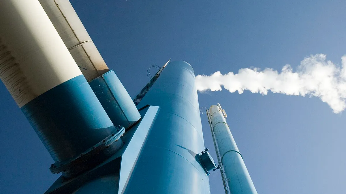 A look upward at a smoke stack with pipes feeding into it