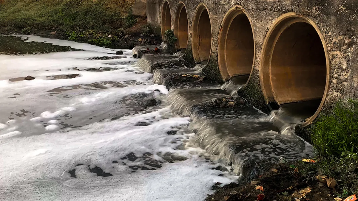 Sewage water flowing into river body and polluting the water and environment.