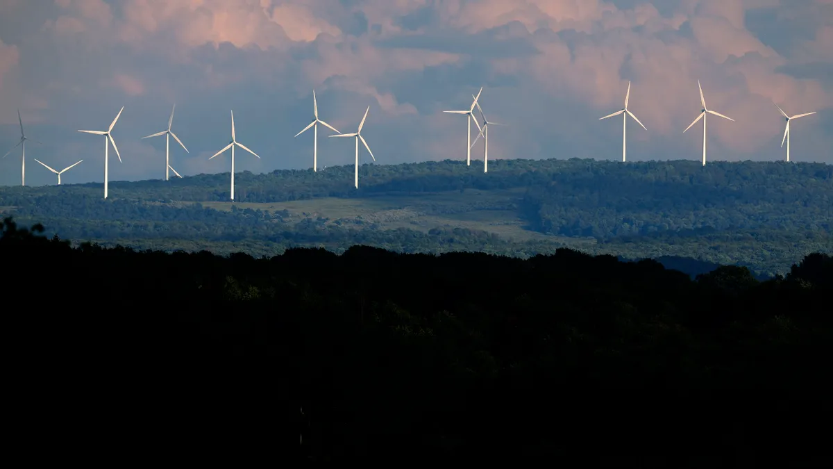 Turbines from the Mount Storm Wind Farm stand in the distance August 22, 2022 in Mount Storm, West Virginia.