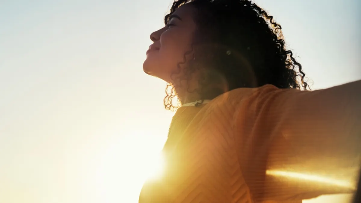 Woman smiling with beautiful sunset as the background.