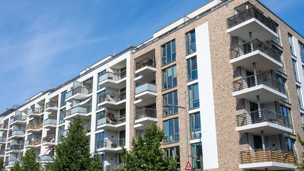 Tan and brown brick apartment building with balconies