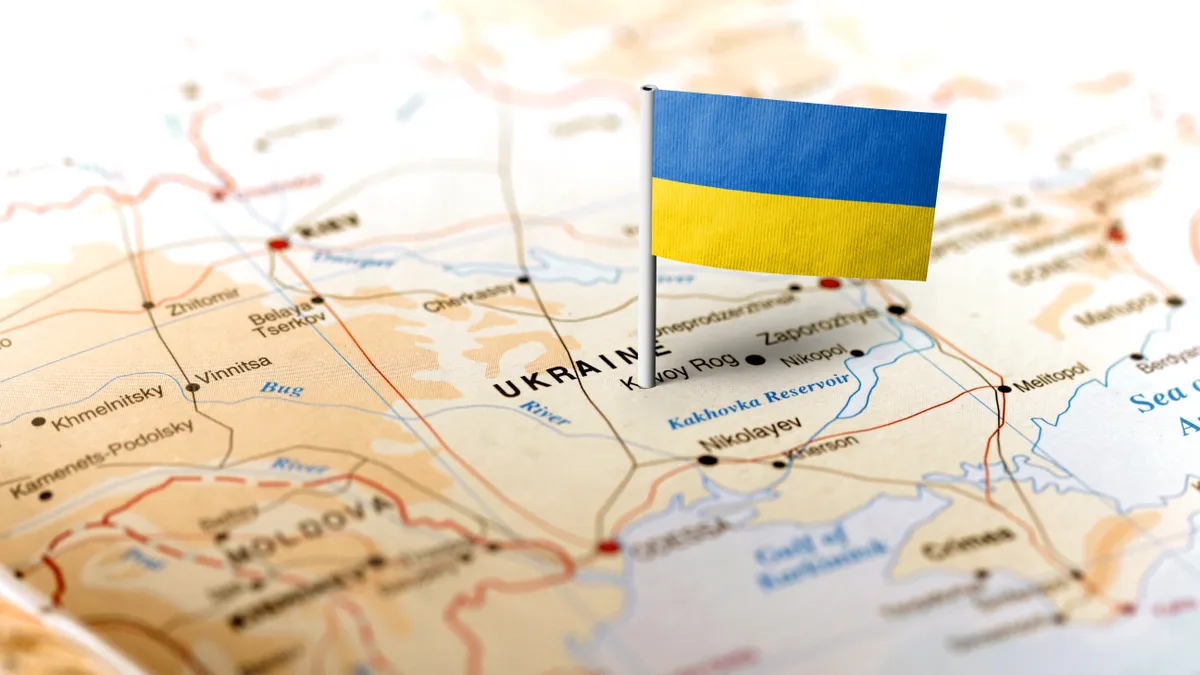 The flag of Ukraine pinned on the map. Horizontal orientation. Macro photography.