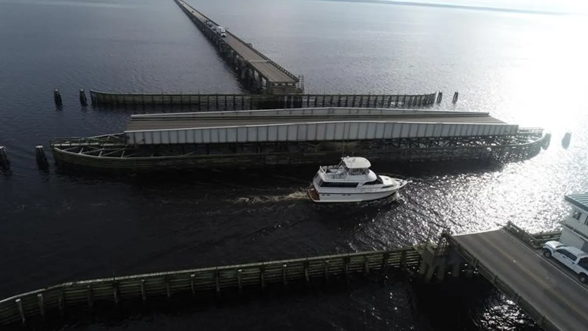 Boats travel through a bridge's swing span.