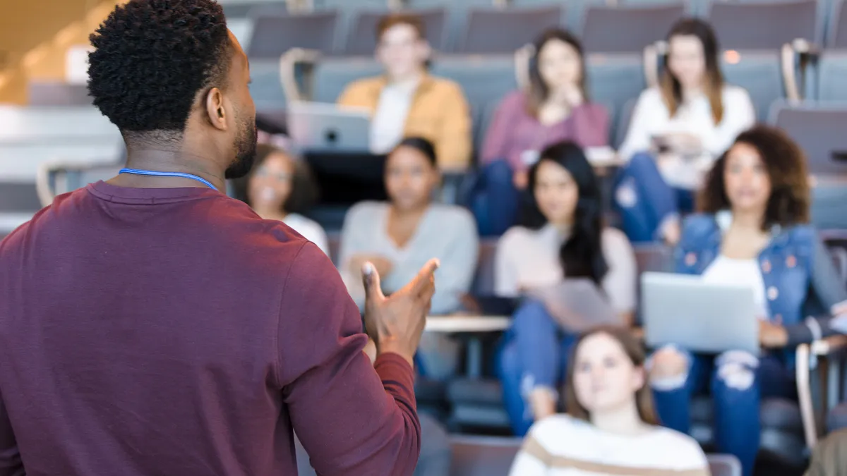 College professor gestures during lecture.