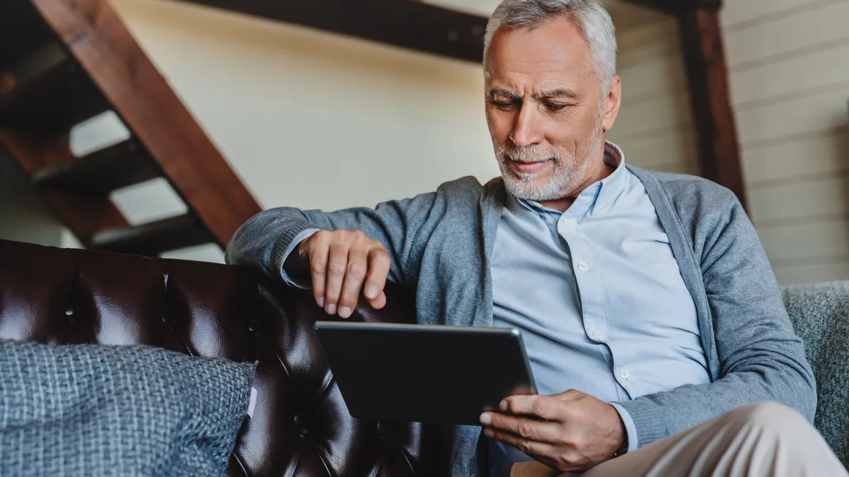 A man browses on his tablet at home