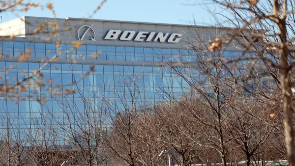 A glass building with a white Boeing logo on the last floor.