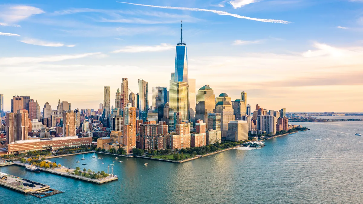 Aerial view with Lower Manhattan skyline at sunset viewed from above Hudson River.