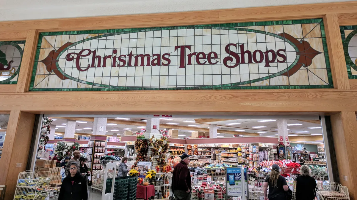 People going in and out of a mall entrance to a Christmas Tree Shops store.