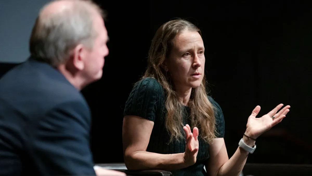 Anne Wojcicki sits in a chair speaking with Marcus Wallenberg during an event.