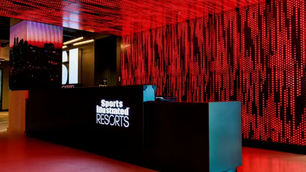 A hotel front desk with the Sports Illustrated Resorts logo.