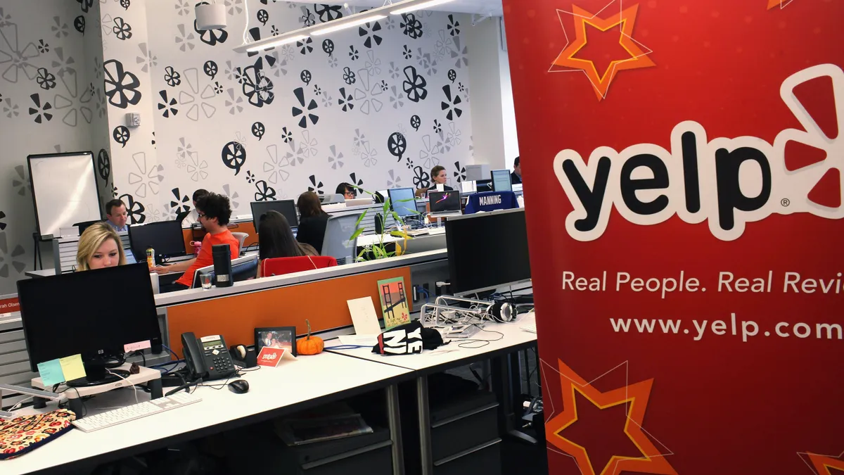 Employees of the online review site Yelp watch as former New York City Mayor Michael Bloomberg speaks at the East Coast headquarters of the tech company on October 26, 2011 in New York City.