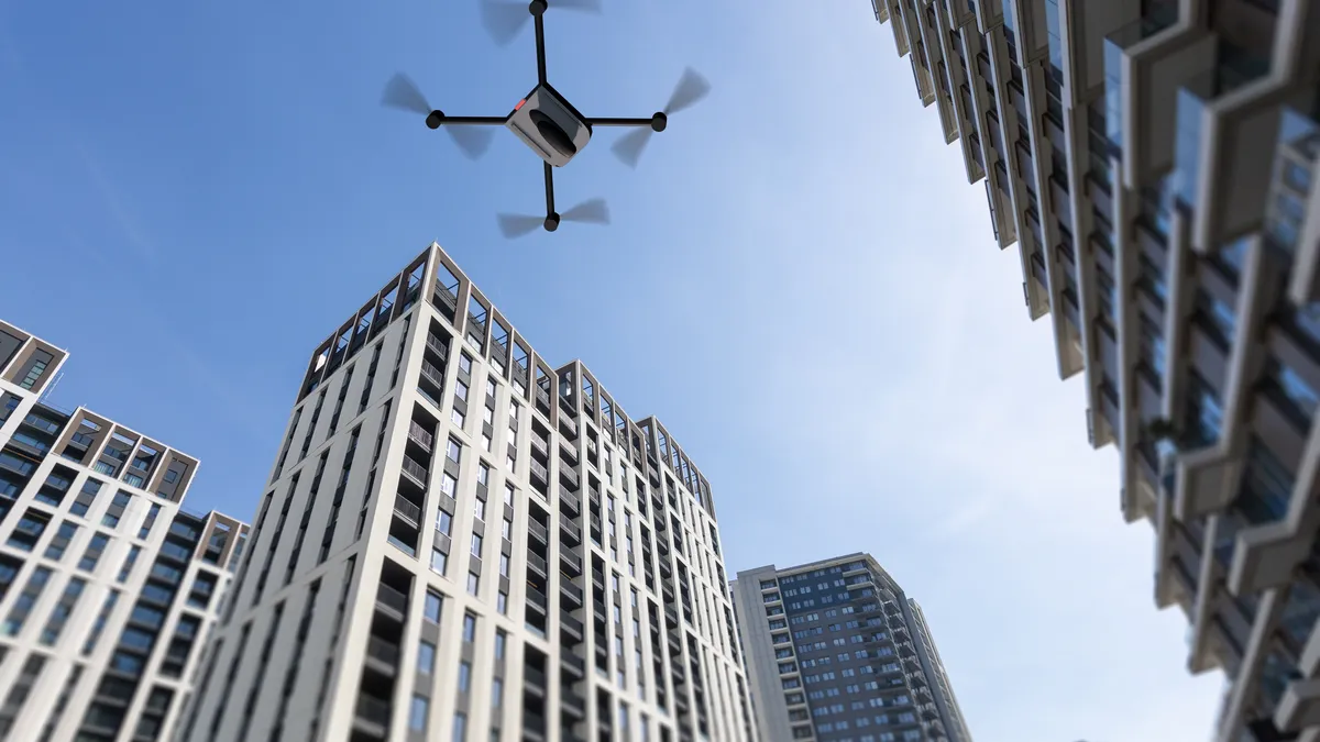 A drone flies next to high-rise buildings.