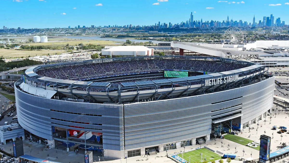 An aerial view of a stadium with the New York City skyline in the background.