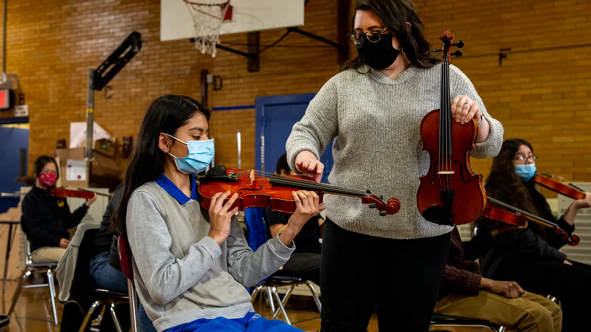 A student and teacher at New York City's MS 118 work together on a music lesson on March 16, 2021.