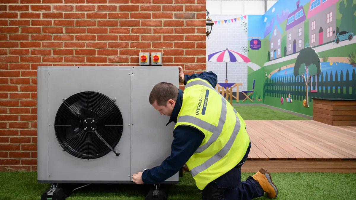 An engineer checks the installation of  heat pump on a model house.