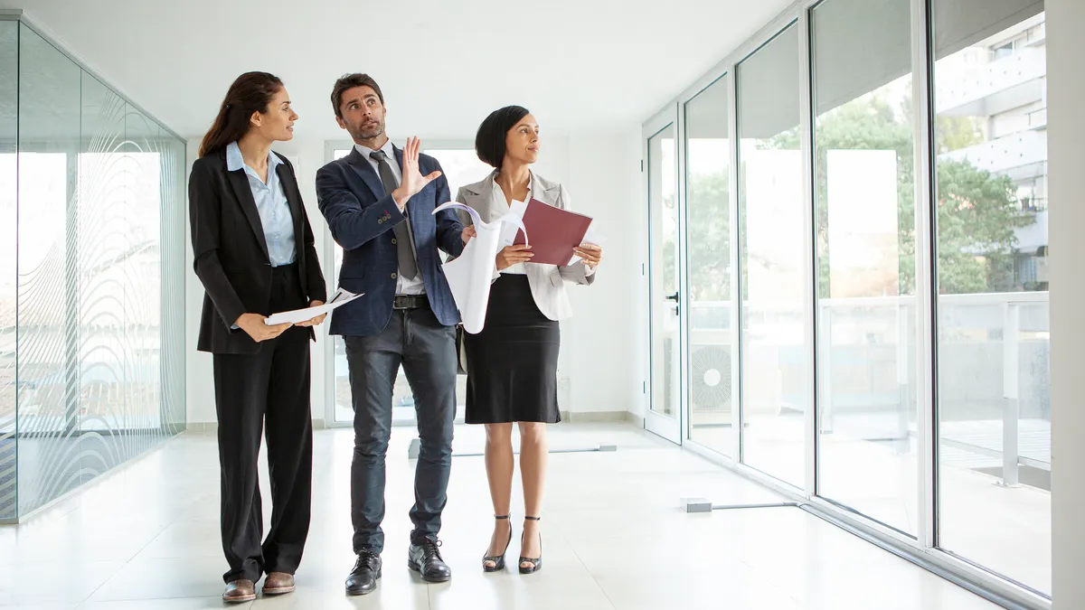 A commercial real estate leasing agent gives a tour inside an empty office.