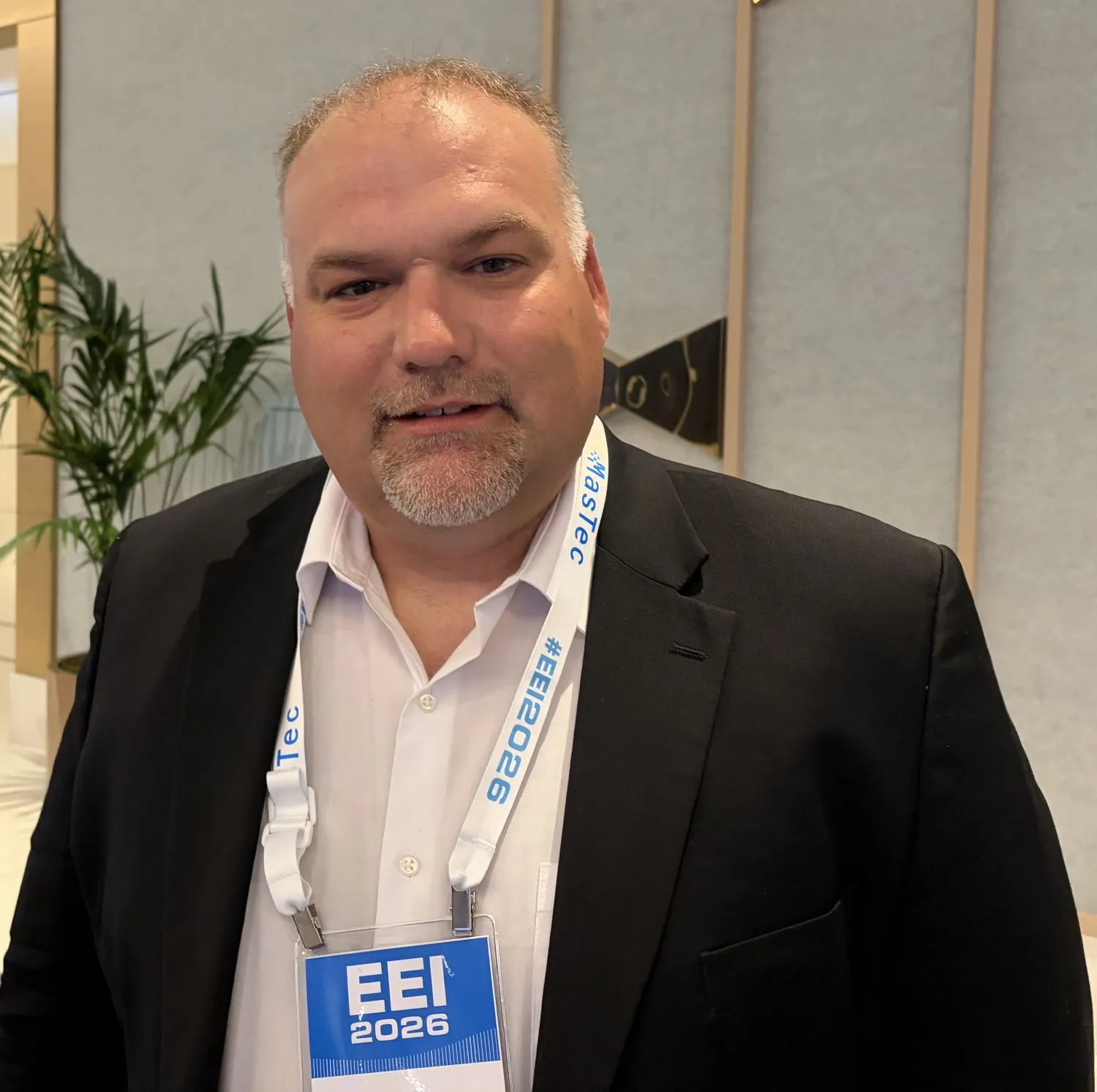 A man wearing an EEI conference badge